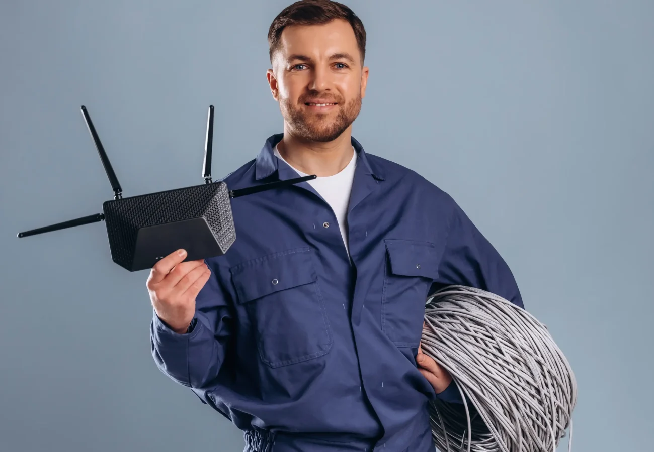 technician-holding-router-and-cable-on-grey-backgr-2026-03-25-09-18-08-utc